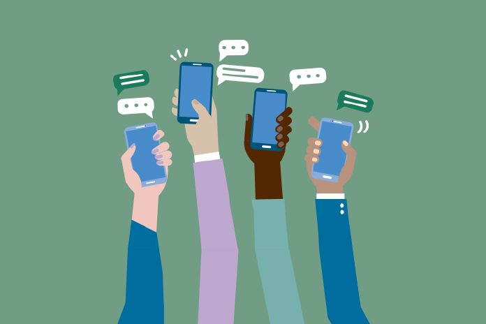 Four arms raising up mobile phones