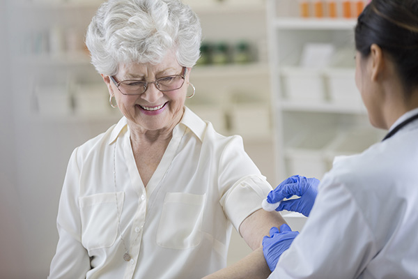 Image displays An older adult receiving her flu vaccine